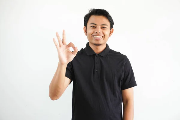 Pemuda Asia Tersenyum Ramah Sambil Memberikan Tanda Tangan Jari Mengenakan — Stok Foto