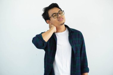 Genç Asyalı adam beyaz arka planda izole edilmiş acı ifadesiyle ensesine dokunuyor..