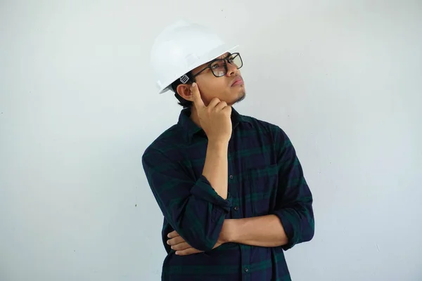 年轻的亚洲男性工程师头戴白色硬礼帽 触摸寺庙思维 为建筑工作与白色背景隔离 复制空间 — 图库照片