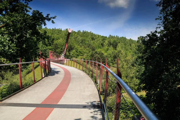 Stock image a bike path bridge with a steel kite at the end of the bridge