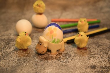 Yumurta kabına boyanmış, arka planda civciv ve kurşun kalemler olan koyun şeklinde.