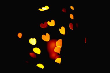 Siyah zemin üzerinde kırmızı, turuncu ve sarı kalpler ile bulanık bokeh - 2 -