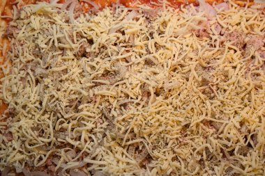 Fırında pizza hamuruna peynir serpiştirilmiş ton balığı ve jambon.