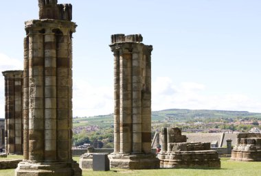 Kuzey Yorkshire İngiltere 'deki manastır harabelerinde sütunlar ve arka planda mavi gökyüzü.