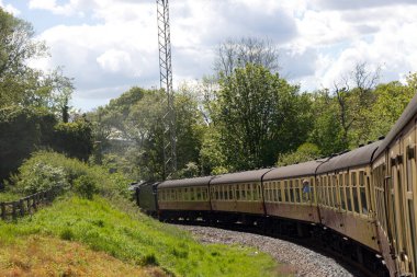 Siyah ve yeşil İngiliz buharlı tren locamotifi # 926 Kuzey Yorksire, İngiltere 'de Kuzey York bozkırlarında ilerliyor..