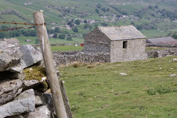 Arka planda Yorkshire Dales İngiltere ile kurumuş taş duvar ve taş bina