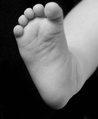  Siyah arka planda bir bebek ayağı.