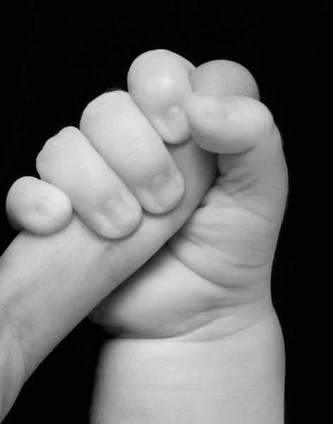 Uma Mão Bebê Segurando Dedo Mindinho Homem Fundo Preto — Fotografia de Stock