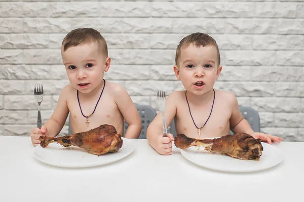 İki aç küçük çocuk iki büyük hindi bacağıyla güzel bir yemek yediler. Şükran Günü