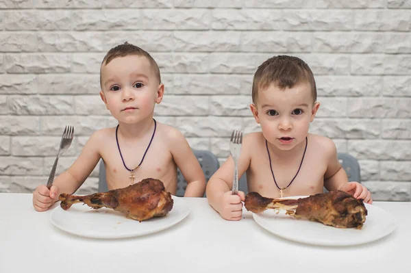 İki aç küçük çocuk iki büyük hindi bacağıyla güzel bir yemek yediler. Şükran Günü