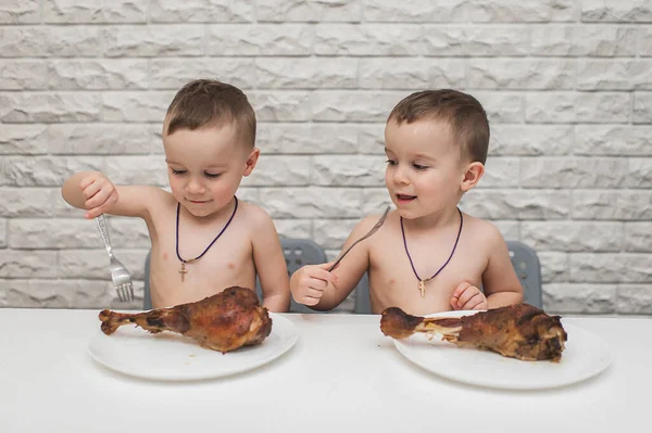 İki aç küçük çocuk iki büyük hindi bacağıyla güzel bir yemek yediler. Şükran Günü