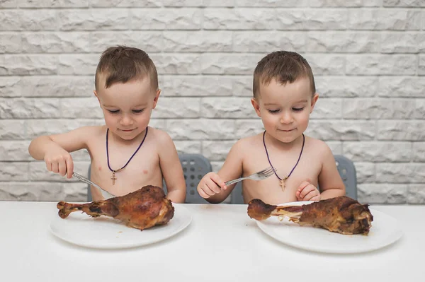 İki aç küçük çocuk iki büyük hindi bacağıyla güzel bir yemek yediler. Şükran Günü