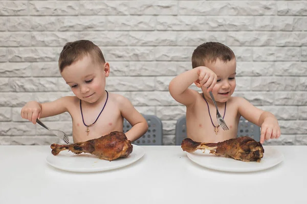 İki aç küçük çocuk iki büyük hindi bacağıyla güzel bir yemek yediler. Şükran Günü