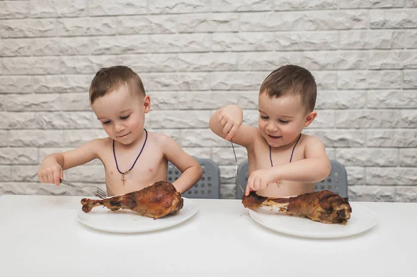 İki aç küçük çocuk iki büyük hindi bacağıyla güzel bir yemek yediler. Şükran Günü
