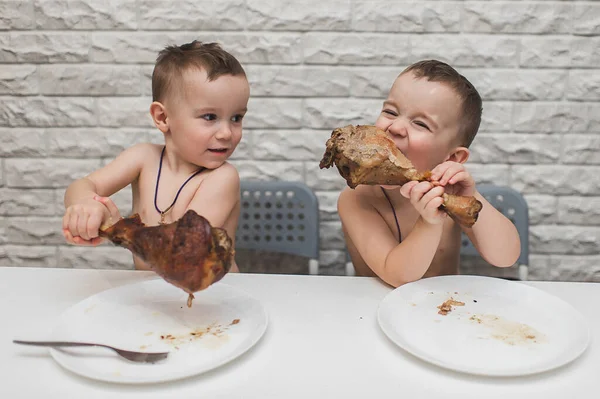 İki aç küçük çocuk iki büyük hindi bacağıyla güzel bir yemek yediler. Şükran Günü