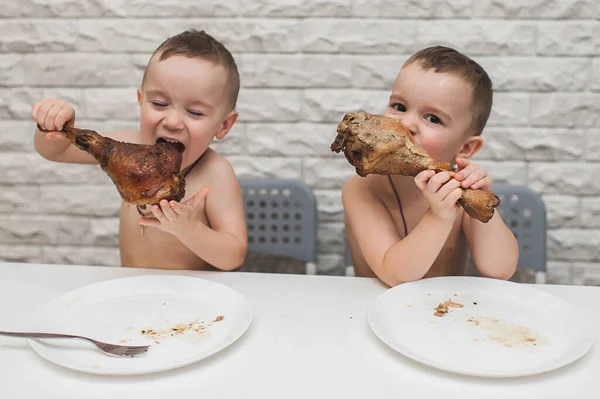 İki aç küçük çocuk iki büyük hindi bacağıyla güzel bir yemek yediler. Şükran Günü