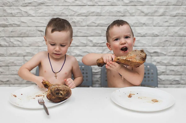 İki aç küçük çocuk iki büyük hindi bacağıyla güzel bir yemek yediler. Şükran Günü