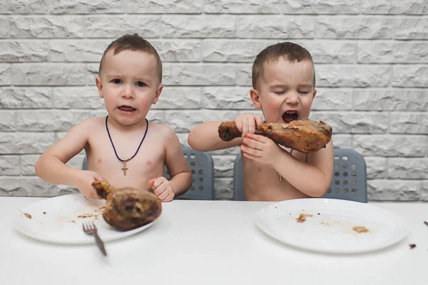 İki aç küçük çocuk iki büyük hindi bacağıyla güzel bir yemek yediler. Şükran Günü