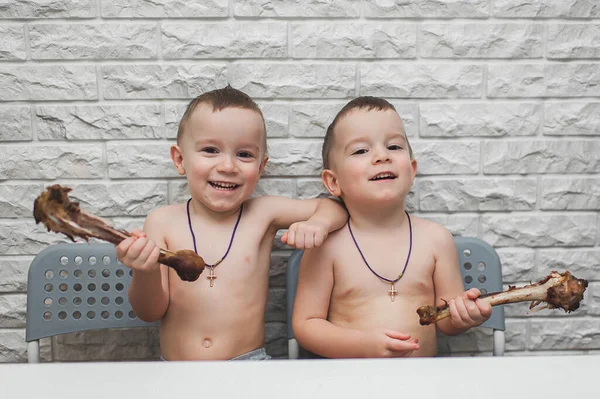 İki aç küçük çocuk iki büyük hindi bacağıyla güzel bir yemek yediler. Şükran Günü