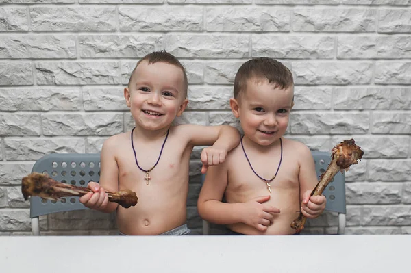 İki aç küçük çocuk iki büyük hindi bacağıyla güzel bir yemek yediler. Şükran Günü