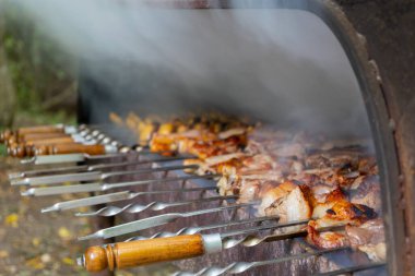 Brezilya usulü ızgarada nefis barbekü pişirme görüntüsü. Lezzetli domuz eti ve patates ızgarada kızartılıyor. Barbeküyü hazırlarken duman çıkıyor..