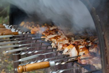 Brezilya usulü ızgarada nefis barbekü pişirme görüntüsü. Lezzetli domuz eti ve patates ızgarada kızartılıyor. Barbeküyü hazırlarken duman çıkıyor..