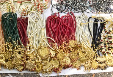 Hindistan 'da satılık çeşitli yapay kadın mücevherlerinin yakın plan seçmeli fotoğrafı.
