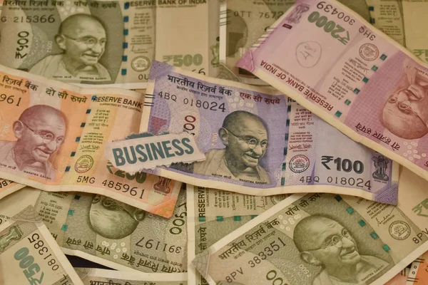 Text Business with Indian currency notes and Coins In Background. Digital finance and Ease of doing business in India.