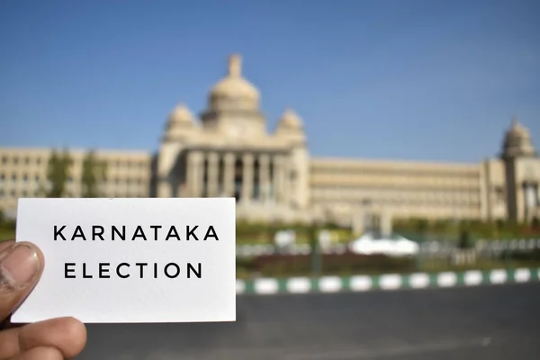 Karnataka Seçimleri bu yıl Nisan 2023 'te yapılacak. Vidhan Soudha 'nın önünde kart tutan bir adam.