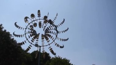Güneşli bir yaz öğleden sonrasında mavi gökyüzüne karşı çalışan eşsiz bir rüzgar değirmeninin videosu..