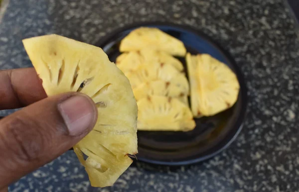 Bir Adam Arka Planda Bir Tabak Dolusu Ananas Parçasıyla Birlikte — Stok fotoğraf