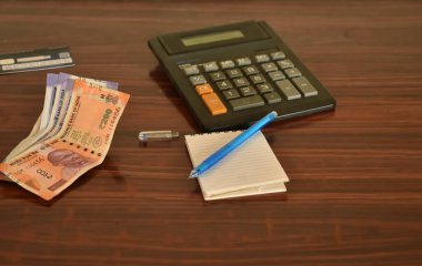 Masadaki Hint para birimi notları ve hesap makinesinin yakın plan fotoğrafı. Finans bütçesi kavramı