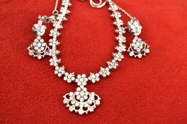 在红色背景下的钻石项链的特写选择性焦点图片 印度珠宝很有名 — 图库照片