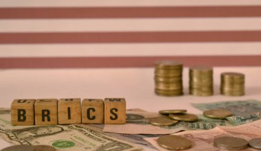 BRICS harflerinin yakın plan seçici odak resmi para birimi notları ve USA Flag ile karşılaştırıldığında