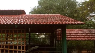 Dökülen kiremit çatısına ya da kalça çatısına düşen muson yağmurlarının yakın çekim videosu