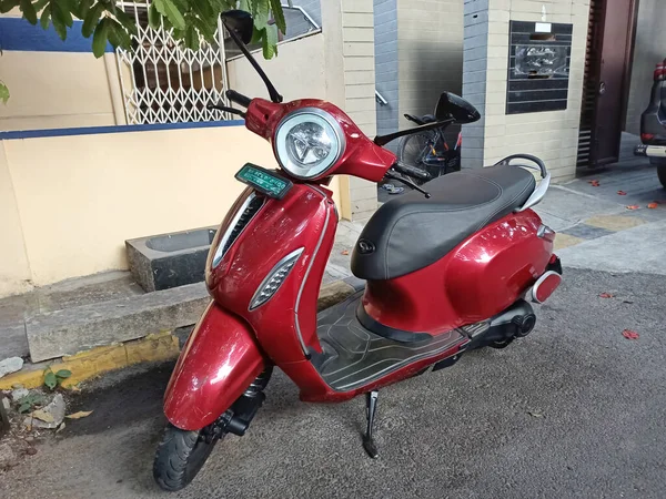 Hindistan 'da bir konutun önüne park edilmiş kırmızı bir scooter' ın yakın plan fotoğrafı..