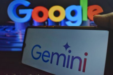 Google Logosuna karşı Gemini Logosu olan cep telefonunu tutan bir adamın resmi.