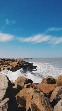 Dalgalar, kumsallar, bulutlu gökyüzü