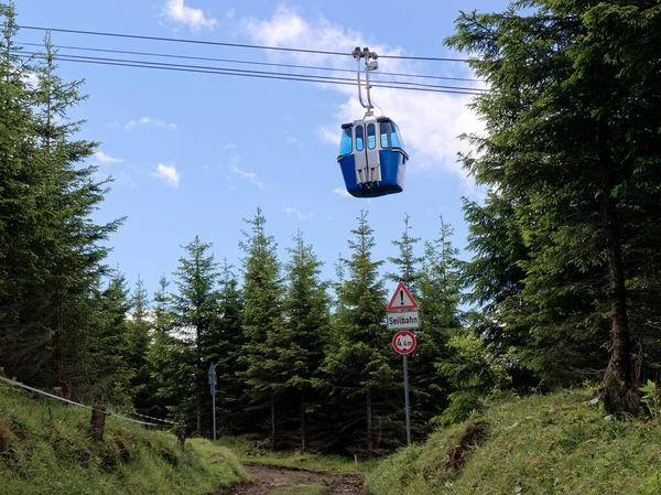 Garmisch-Partenkirchen, Otuzbir Dağı 'ndaki teleferik vagonunda yürüyüş parkurunun üzerinden geçerken uyarı işareti var..