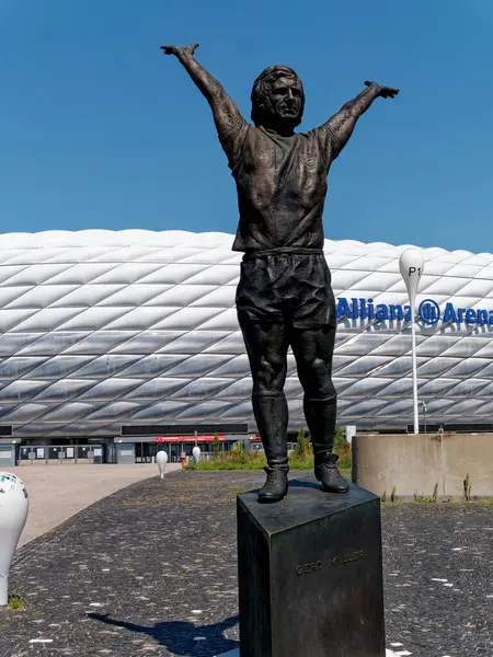 Münih, Almanya - 13 Ağustos 2024. Arka planda Münih 'teki Allianz Arena. Ön planda futbolcu Gerd Mueller 'in heykeli, dış görünüş.