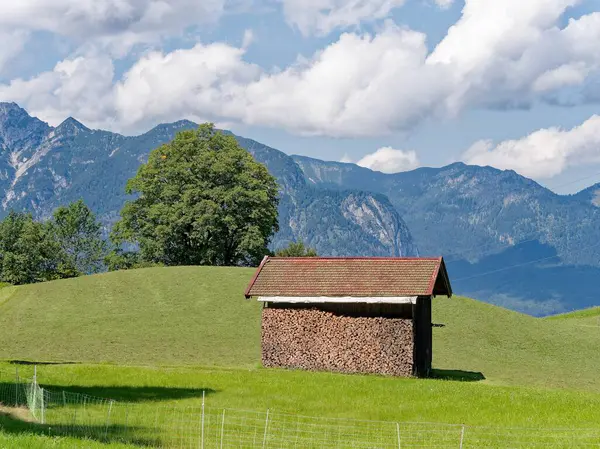 Bavyera 'daki Garmisch-Partenkirchen dağlarında bir yürüyüş yolunda ahşap kulübe. Arka planda dağlar