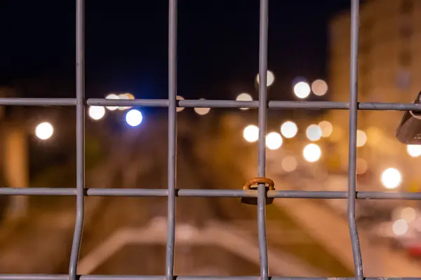 Stock image approach of a closed padlock on a fence