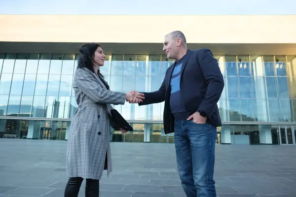 İş adamları, modern bir binanın önünde anlaşmaya vardıktan sonra iki iş adamının el sıkışması. Yüksek kalite fotoğraf