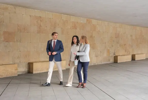 İş adamları konuşuyor ve gülümsüyor. Üç iş adamı kentte bir arada duruyor, konuşuyor ve gülümsüyor. Yüksek kalite fotoğraf