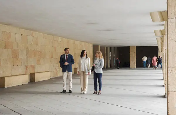 İş adamları konuşuyor ve gülümsüyor. Üç iş adamı kentte bir arada duruyor, konuşuyor ve gülümsüyor. Yüksek kalite fotoğraf