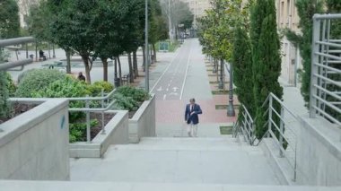 İş adamı merdivenlerden yukarı koşuyor şehir ortamında şehir ortamında merdivenlerden çıkıyor. Yüksek kalite 4k görüntü