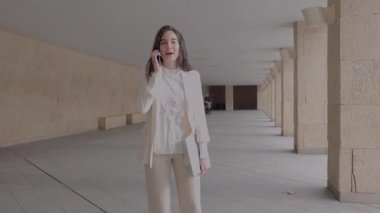 İş kadını koridorda yürürken ve konuşurken kolonları vardı.