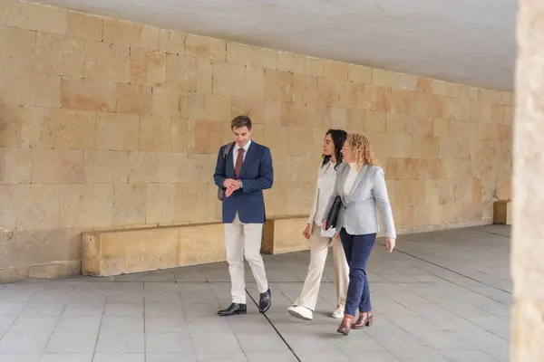 İş adamları konuşuyor ve gülümsüyor. Üç iş adamı kentte bir arada duruyor, konuşuyor ve gülümsüyor. Yüksek kalite fotoğraf