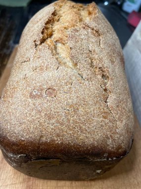 close-up of a loaf of freshly prepared bread with fresh ingredients on rustic wooden table