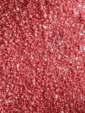 red background, texture of a shiny metallic surface of a pink glitter